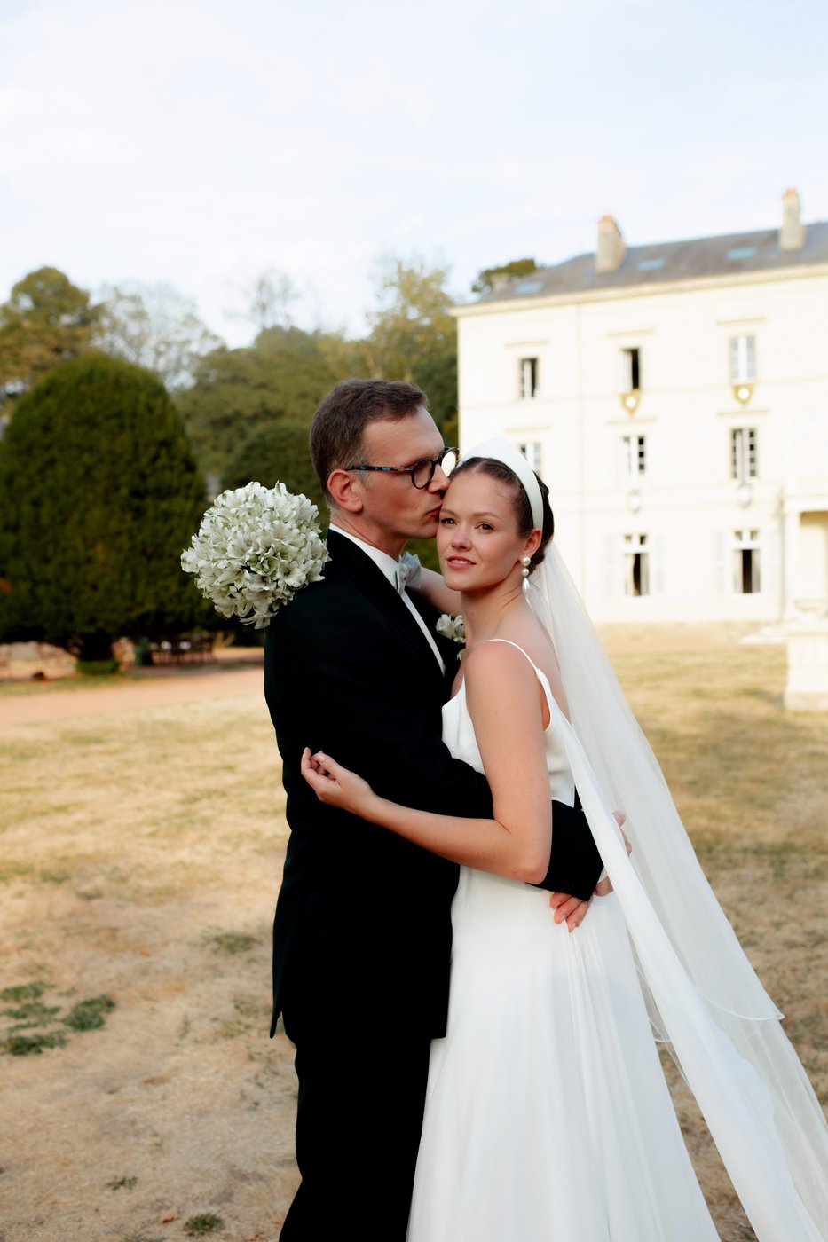 Marié embrassant le front de la mariée, tendresse en extérieur